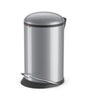 silver-colored trash bin with a built-in foot pedal. Lid is in closed stance.