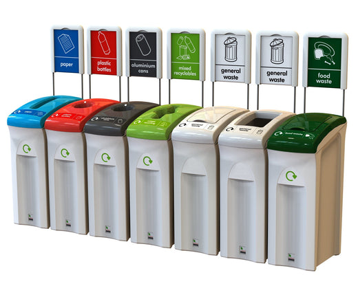 7 litter bins with multi colored lids, different apertures and signages on top. 1 light green, 1 dark green, 1 light blue, 1 black, 1 red, 2 white.