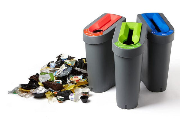 3 Internal Ubins with red hole, blue slot and mixed recycling inserts next to a pile of waste