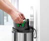 Brabantia flat back bin against a wall with the plastic liner being pulled out