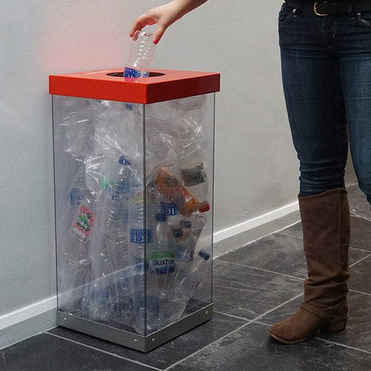 Transparent recycling bin with red hole aperture lid.  Bin full of plastic bottles