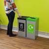 Internal recycling station in location with each bin with a silver body and graphics to the front.  Black general waste lid and lime green lid to signify waste streams