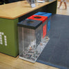 Freestanding triple recycling bin with 3 clear bodies and iconography for cans, plastics and paper