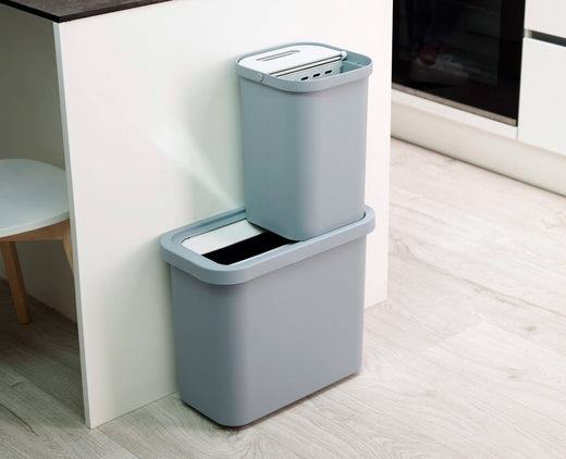 A 14-litre grey recycling caddy, divided into two 7-litre stacked compartments, next to the kitchen counter.