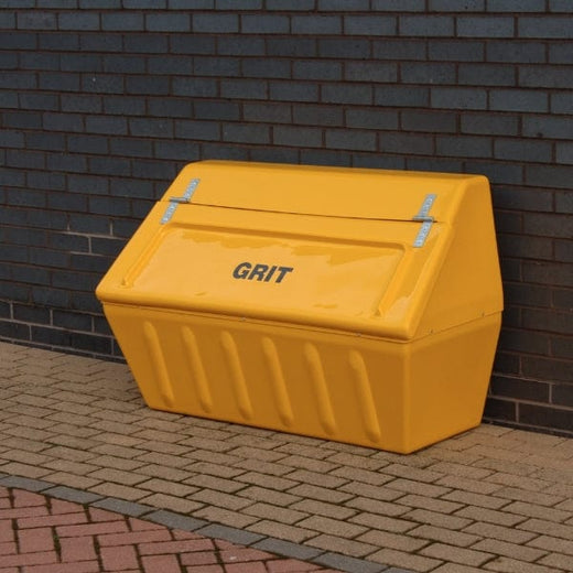  a big GRP grit container in yellow placed on a dry road.