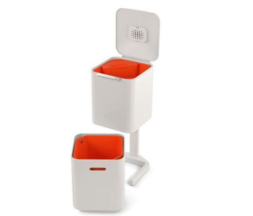  a stone-colored waste bin with two separate compartments and a detachable orange caddy in the top bin.