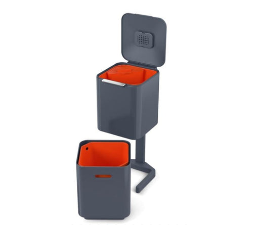 Totem Waste Bin with 2 unattached compartments in graphite color. Upper bin has a removable orange caddy for food waste.