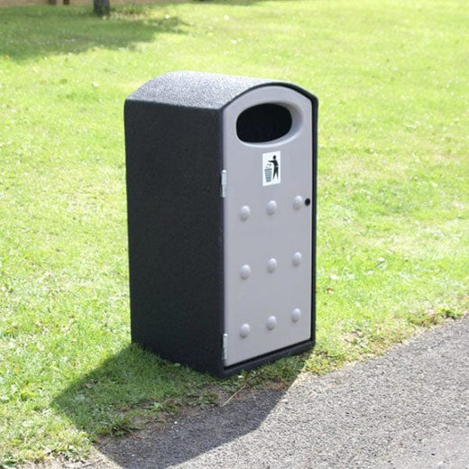 Trash can is placed outside. It has white aperture and domed lid. 