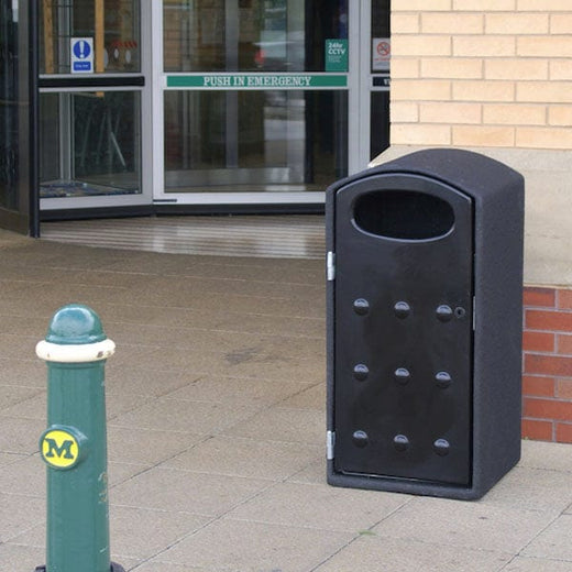 Litter bin with black throw in aperture  is situated at the entrance of an establishment.  