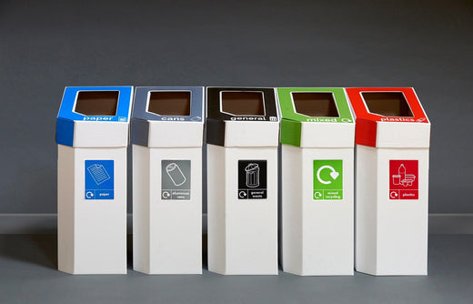 5 trash bins made from cardboard, with different coloured lift off lids in blue, grey, black, green, and red.