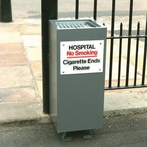 Ground mountable cigarette bin with perspex plate with wording to the front, powder coated in grey
