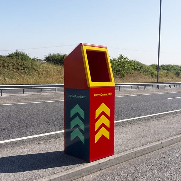 Side view of the roadisde litter bin.  Red metal body with yellow surround aperture complete with chevron icons to all sides
