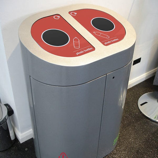Two compartment recycling bin with doors closed and 2 red apertures on the top for plastic bottle recycling